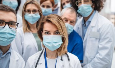 group-of-doctors-with-face-masks-looking-at-camera-ZAL8RZC.jpg