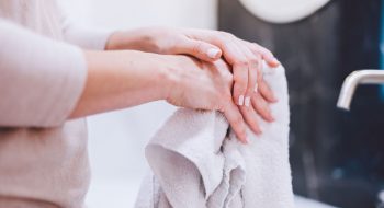 woman-wiping-hands-in-towel-after-washing-them-hyg-22ZGBH4.jpg
